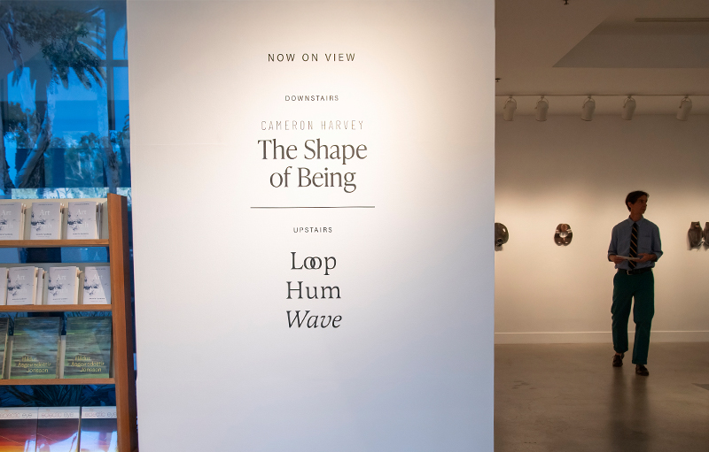 Gallery space with the sign showcasing the names of two distinct shows